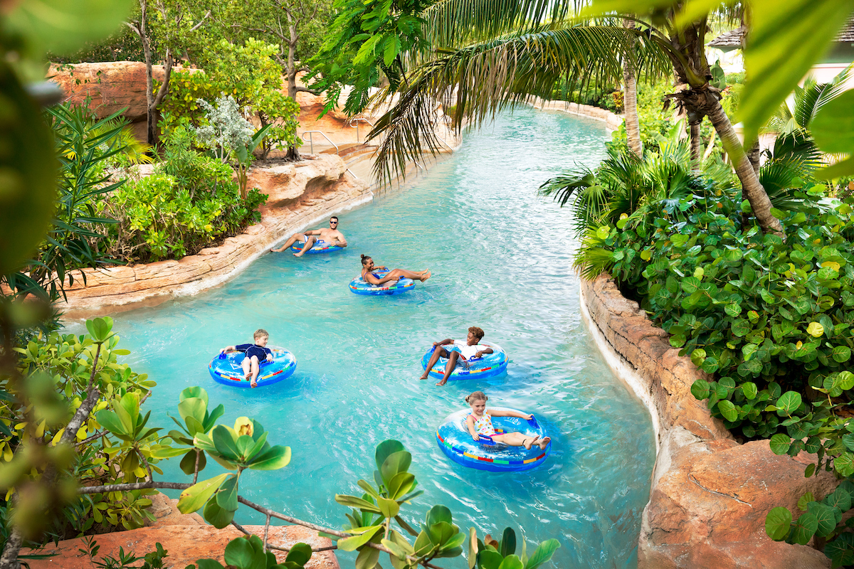 Two adults and three children float down The Rapids River on inner tubes at Atlantis Paradise